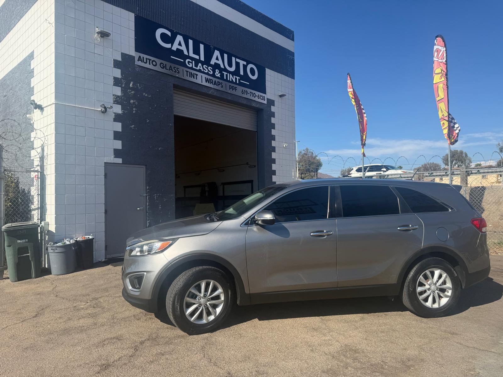 Gray Kia Sorento SUV after window tint installation parked outside Cali Auto Glass and Tint in El Cajon